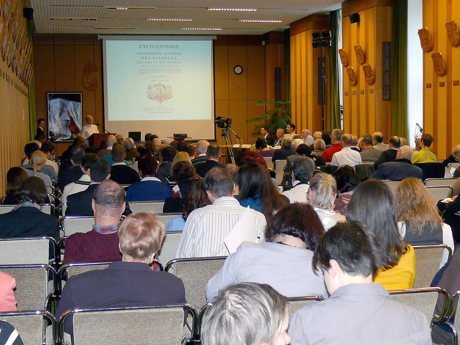 Delegates seated in a conference hall during a plenary session.